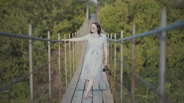 Woman in a Beautiful Dress, Standing on a Bridge in Woods