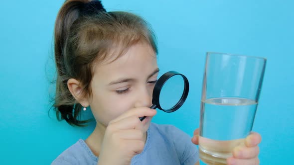 The Child Looks at the Water with a Magnifying Glass