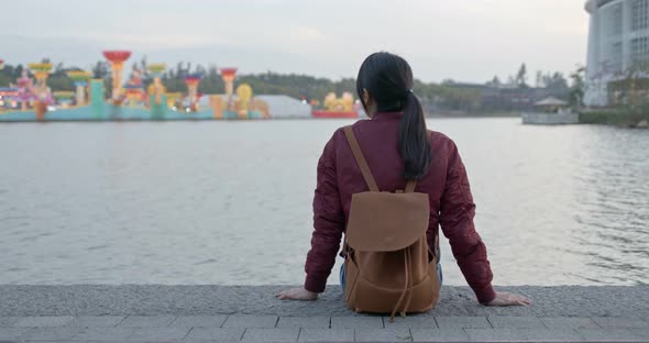 Woman enjoy the sunset view and sit besides the river