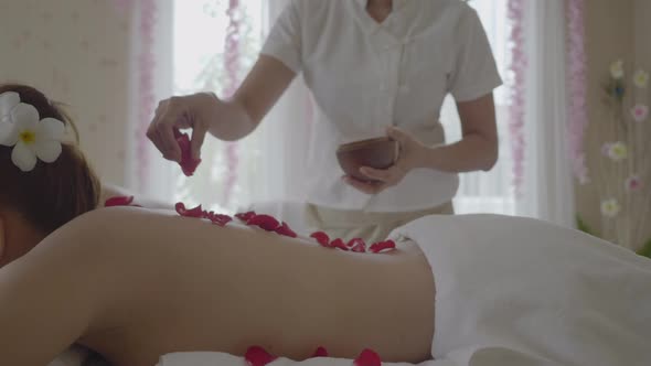 Young beautiful woman in Spa massage salon. Relax treatment with smell of roses flowers.