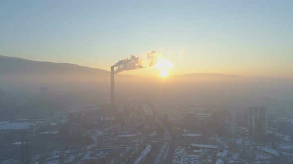 Big Industrial Chimney Pipes Smoking in the Air at Sunset