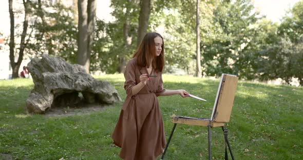 Girl Artist Paints in the Park