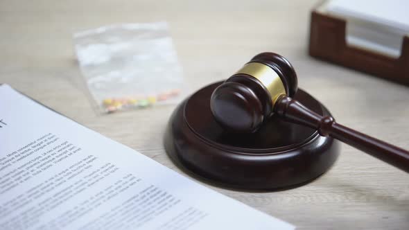 Drug Pills on Table, Gavel Striking on Sound Block, Illegal Medicine, Judgment