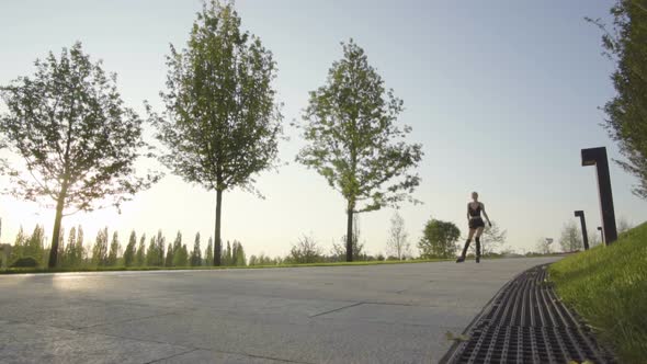 Beautiful Young Woman On Rollerblading In Park At Sunrise