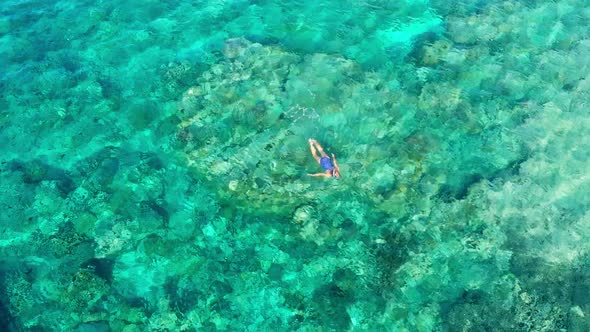 Aerial slow motion: woman snorkeling on coral reef tropical caribbean sea