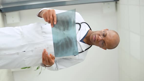 Young African American Doctor Standing in Medical Suit at Clinic and Looking at Camera