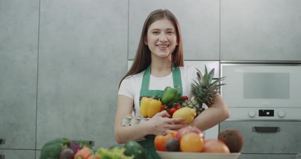 A Girl Smiling Holding Nutritious Fruit and Veg.