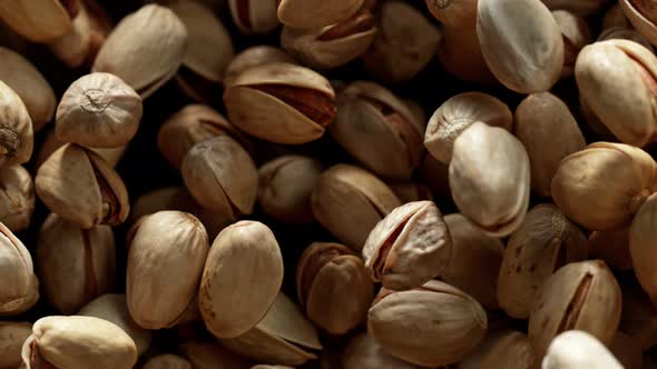 Super Slow Motion Shot of Pistachios Flies After Being Exploded Against Black Background, 1000Fps.