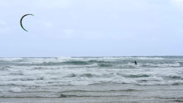 SLOW MOTION Kite Boarder Surfs Through Waves On Windy Ocean Water