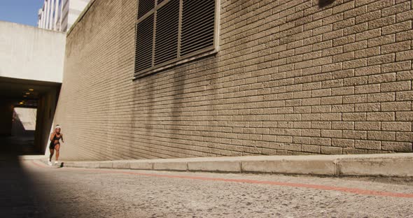 African american woman exercising outdoors running next to bridge in the city