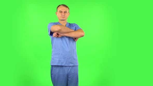 Medical Man Folds His Arms Over His Chest and Looks Seriously at the Camera. Green Screen