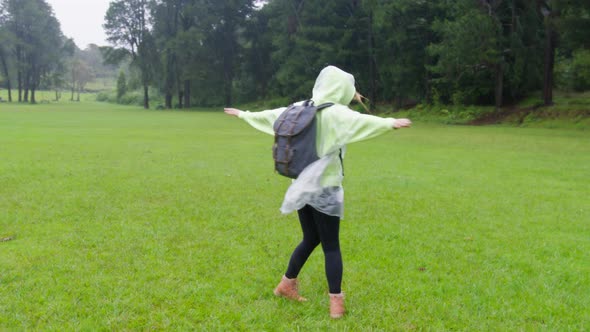 Happy Cute Smiling Young Woman with Raised Hands in Raincoat Enjoying Rain RED