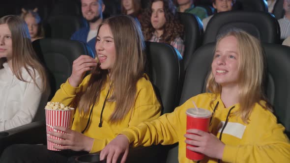 Young Laughing Female Teenagers in Movie Theater