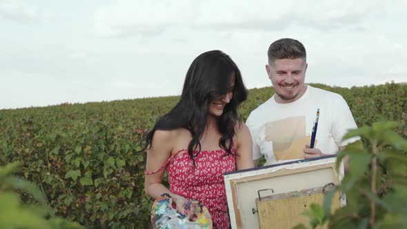 Couple of Happy Artists Having Fun in the Summer Field When Painting Landscape