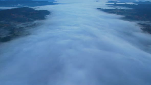 4K Scenic flight over beautiful mountain scape with bright sky and clouds