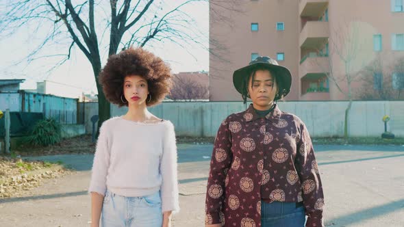 Two women standing in backyard looking at camera