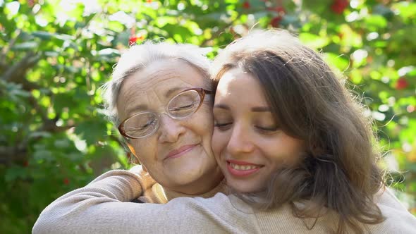 Happy Senior Mother in Eyeglasses is Hugging Her Adult Daughter the Women are Enjoying Together