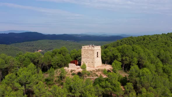 parallax aerial drone shot of soldiers tower in avinyó green dense forest. Mountains of catalonia sp