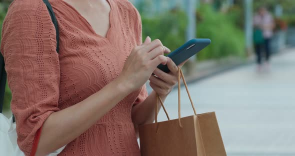 Woman hold shopping bag with cellphone
