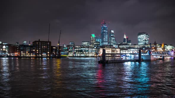 River bus arrives at the Bankside Pier in the Thames, skyscrapers of the City of London behind.