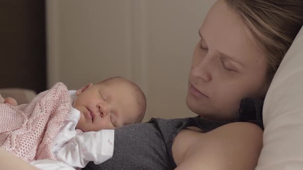 Mother and Newborn Daughter Sleeping Together in Daytime