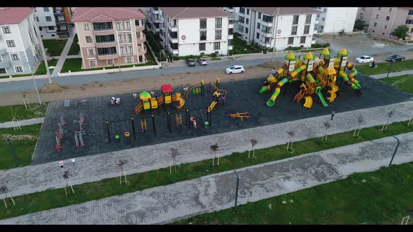 Children's Playground with Playing Children in the Spring Park at the End of the Quarantine