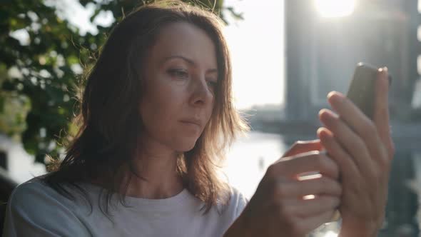 Internet Addiction of Modern People Woman is Viewing Social Nets By Smartphone at Street