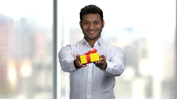 Smiling Indian Man Giving Gift Box.