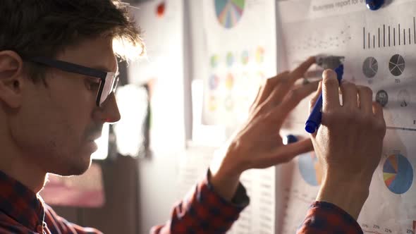 The Businessman Examines Documents with Diagrams and Graphs