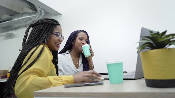 Two young women in the office, working together from the computer