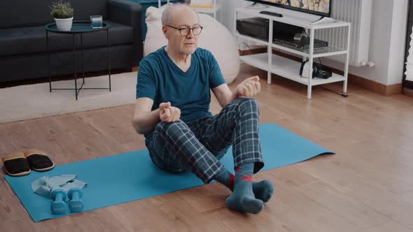 Calm Pensioner in Lotus Position Doing Meditation to Relax