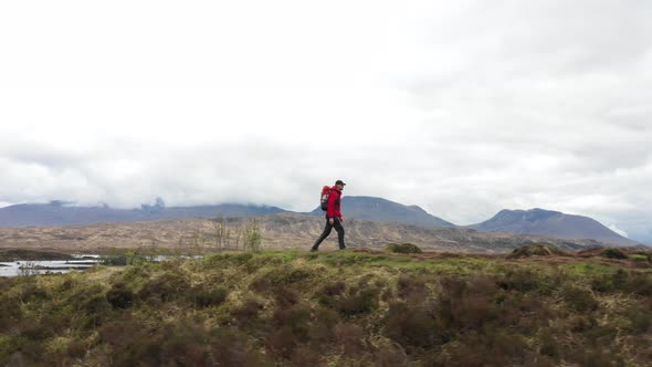 Man adventurer with backpack exploring Highlands in Scotland