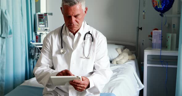 Male doctor using digital tablet in ward