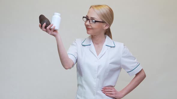 Nutritionist Doctor Holding Organic Avocado Fruit and Jar of Medicine or Vitamin or Omega 3 Capsules