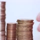 A woman's hand puts coins in a column. Investment concept. Metallic currency - VideoHive Item for Sale