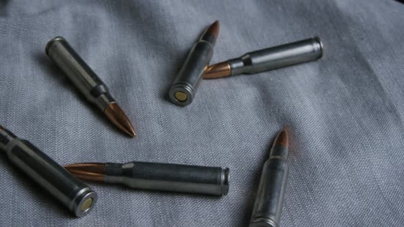 Cinematic rotating shot of bullets on a fabric surface - BULLETS 108