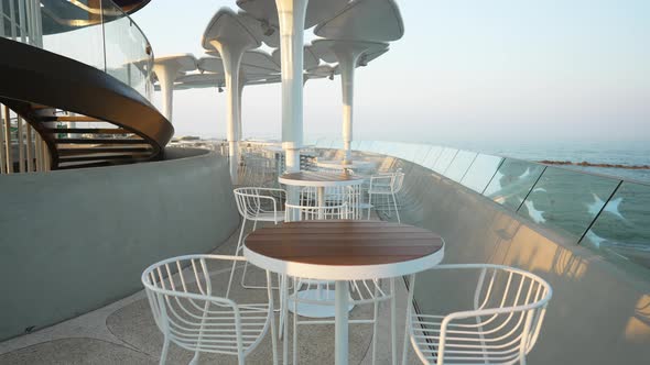 Live Camera Moves Forward Along Coffee Tables in Outdoor Cafe with Blue Mediterranean Sea at