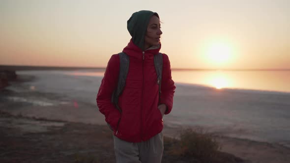 Pretty Young Female Hiker Walking Along Incredible Golden Sunrise Sea Beach at Cold Morning