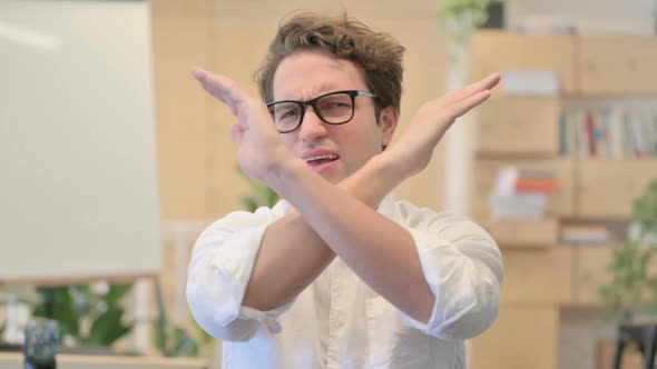 Portrait of Young Man Showing No Sign By Arm Gesture