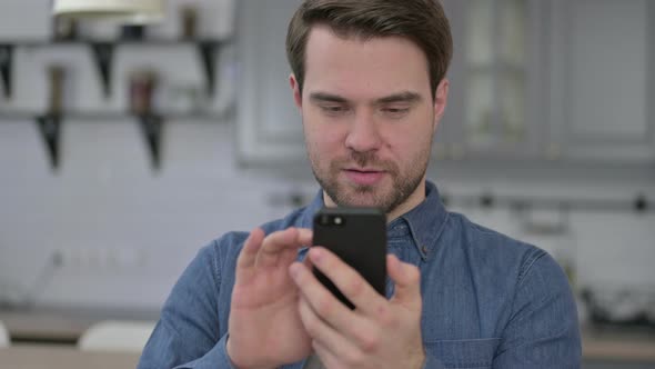 Portrait of Beard Young Man Celebrating Success on Smartphone