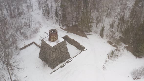 Aerial shot orbiting around Katahdin Ironworks in Winter snowfall