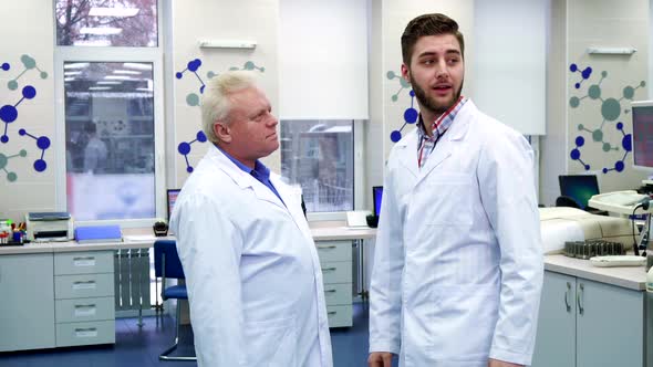 Two Male Scientists Greet Each Other at the Laboratory