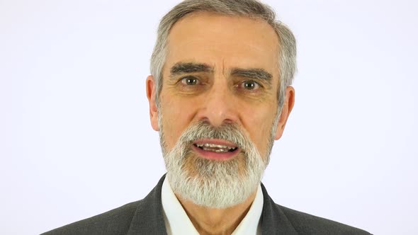 An Elderly Man Talks To the Camera with a Smile - Face Closeup - White Screen Studio