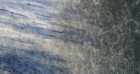 Aerial view of frozen lake with people ice skating