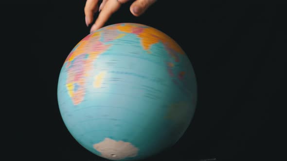 Geographical Globe is Twisted Around Its Axis By a Female Hand