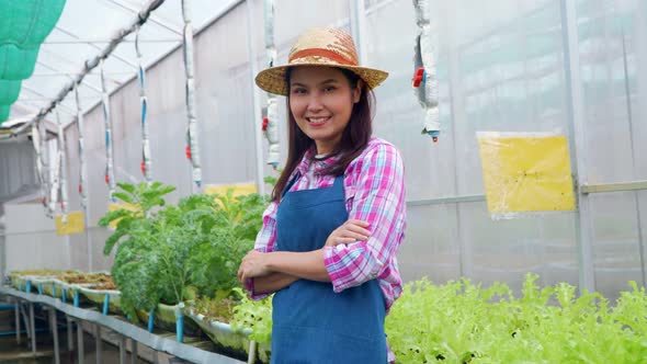 Zoom in Portrait of happy Asian woman farmer and after checking fresh vegetable salad for finding pe