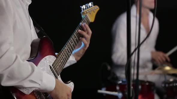 The Guitar Player Is Very Active on Stage with His Rock Band. Close-up