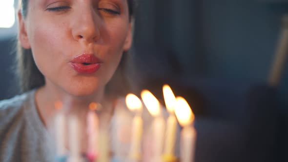 Happy Excited Woman Making Cherished Wish and Blowing Candles on Holiday Cake Celebrating Birthday