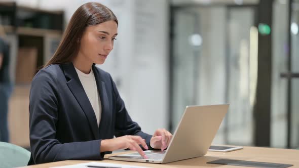 Businesswoman Celebrating Success on Laptop in Office