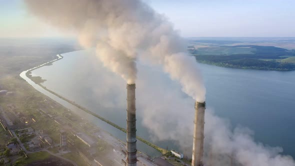 Aerial view of coal power plant high pipes with black smokestack polluting atmosphere